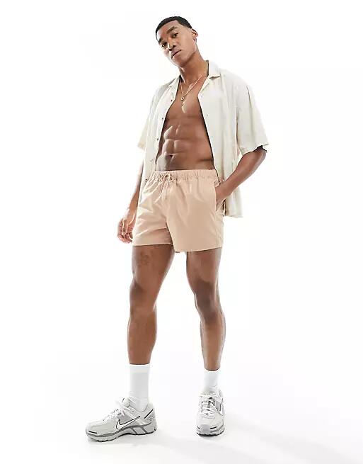 ASOS DESIGN swim shorts in short length in brown Cover