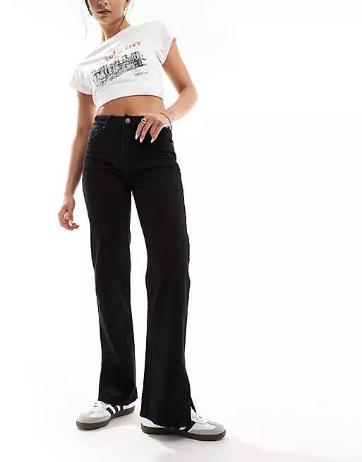 Bershka split hem flare jeans in black Cover