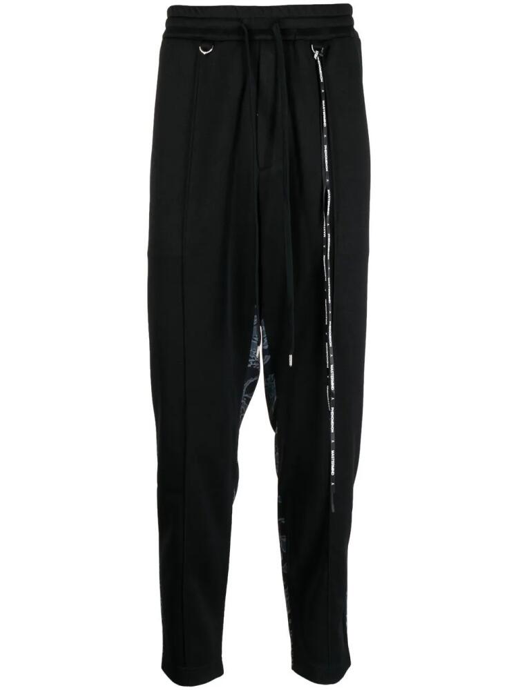 Mastermind World camouflage-print track pants - Black Cover