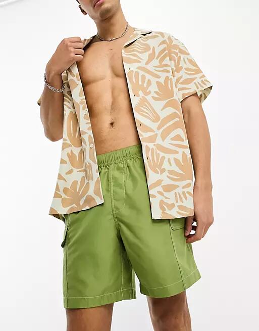 ASOS DESIGN swim shorts in mid length with cargo pockets in green Cover