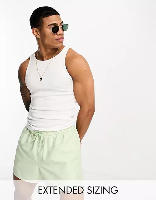 ASOS DESIGN swim shorts in short length in light green Cover