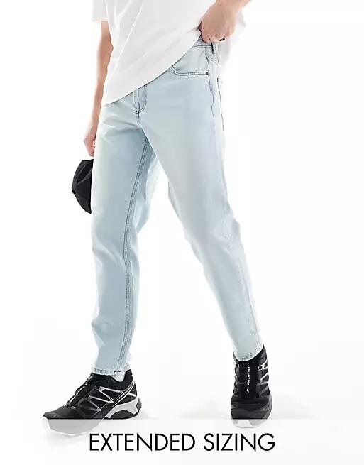 ASOS DESIGN tapered fit jeans in light wash blue Cover