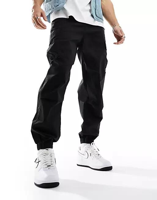 ASOS DESIGN oversized tapered cargo pants with cuff in black Cover